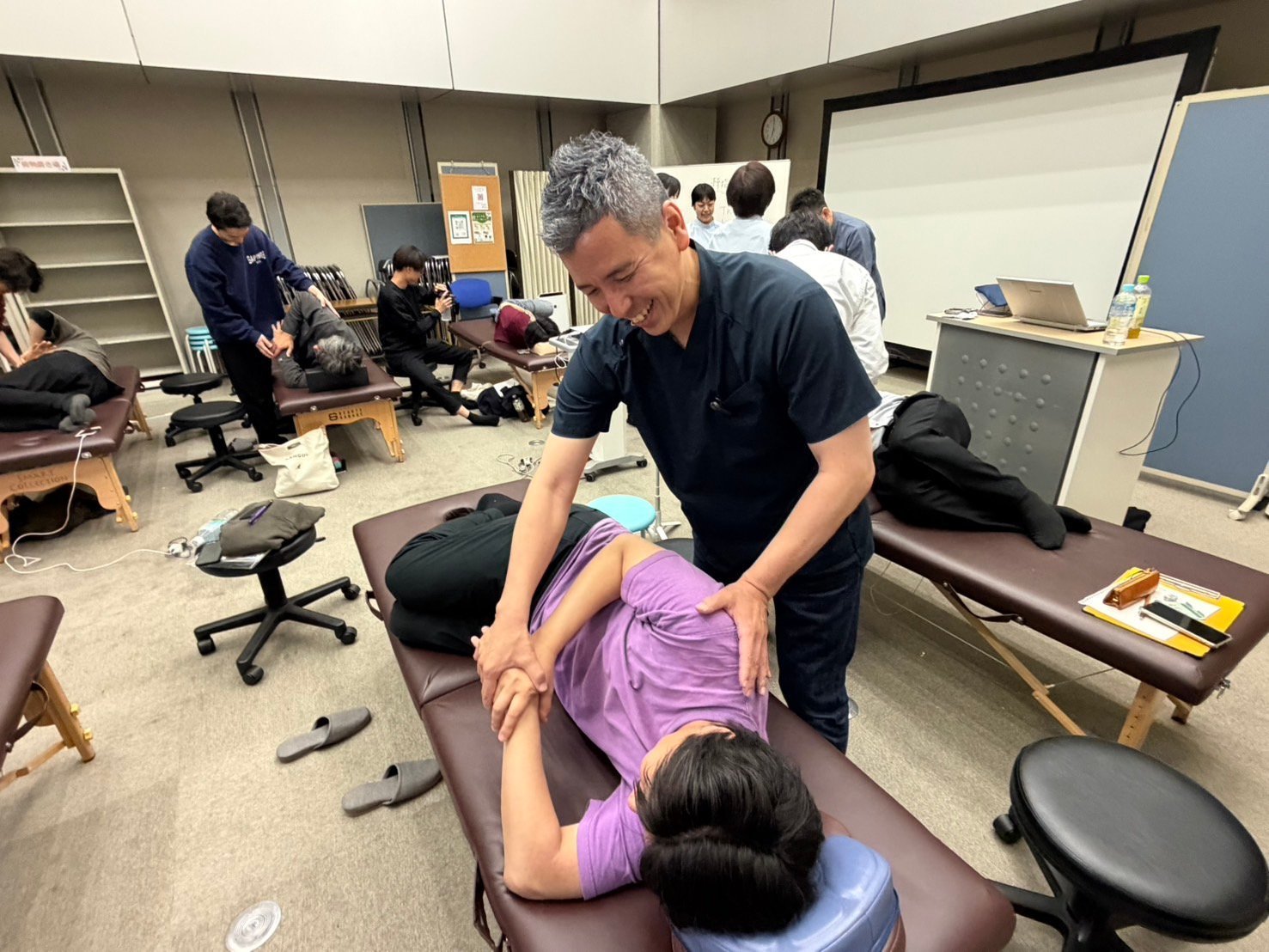 受講生の先生を相手に、施術の実技を見せる院長
